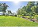 Expansive backyard with a well manicured lawn, lush plants and a glimpse of the lake at 2611 State Road 557, Lake Alfred, FL 33850