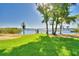Lush green lawn leading to the waterfront, complete with a charming pier at 2611 State Road 557, Lake Alfred, FL 33850