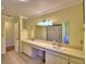 The bathroom has double sinks, tile flooring, and white trim with a picture on the wall at 2611 State Road 557, Lake Alfred, FL 33850