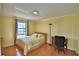 The bedroom has a hardwood floor, crown molding, and a window with curtains at 2611 State Road 557, Lake Alfred, FL 33850