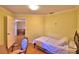 Bedroom featuring a single bed and chair, with a doorway view of living room at 2611 State Road 557, Lake Alfred, FL 33850