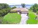 House with large lawn, mature trees, long driveway, and two-car garage at 2611 State Road 557, Lake Alfred, FL 33850