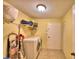 Laundry room with washer, dryer, utility sink, storage shelves, and access door at 2611 State Road 557, Lake Alfred, FL 33850