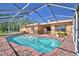 Screened in pool with brick decking is surrounded by potted plants and French doors to the home's interior at 2611 State Road 557, Lake Alfred, FL 33850