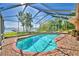 Screened pool features a brick deck and views of the lake and private dock beyond the enclosure at 2611 State Road 557, Lake Alfred, FL 33850