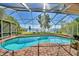 Screened pool features a brick deck and views of the lake and private dock beyond the enclosure at 2611 State Road 557, Lake Alfred, FL 33850