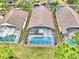 An aerial view of screened-in pools behind three homes, offering a private outdoor oasis at 2721 Kokomo Loop, Haines City, FL 33844