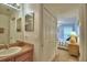 Bathroom with vanity, sink, mirror, and closet with doors leading to bedroom at 2721 Kokomo Loop, Haines City, FL 33844