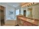 Bright bathroom with a large soaking tub, a vanity area and a glass enclosed shower at 2721 Kokomo Loop, Haines City, FL 33844
