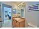 Bathroom featuring a single sink vanity with framed mirror and view to living area at 2721 Kokomo Loop, Haines City, FL 33844