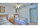 Bright bedroom featuring two twin beds with gray plaid bedding, a lamp, and entryway at 2721 Kokomo Loop, Haines City, FL 33844