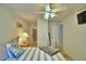 Bedroom featuring a queen bed with striped bedding, lamps, and attached bathroom at 2721 Kokomo Loop, Haines City, FL 33844