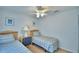 Bright bedroom featuring two twin beds with blue striped bedding and a ceiling fan at 2721 Kokomo Loop, Haines City, FL 33844