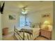 Bedroom featuring a queen bed with striped bedding, ceiling fan, and wall art at 2721 Kokomo Loop, Haines City, FL 33844