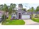 Charming single-story home featuring a well-manicured lawn, mature palm trees, and a two-car garage at 2721 Kokomo Loop, Haines City, FL 33844
