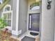 Close up of the front entry featuring a decorative window, a Ring doorbell and manicured landscaping at 2721 Kokomo Loop, Haines City, FL 33844