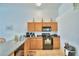 Functional kitchen with light wood cabinets, black appliances, and neutral countertops at 2721 Kokomo Loop, Haines City, FL 33844