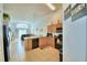 Well-lit kitchen with light wood cabinets and black appliances, flowing into an open living space at 2721 Kokomo Loop, Haines City, FL 33844