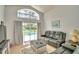 Living room with high ceiling, large window, sliding door, and a gray sofa at 2721 Kokomo Loop, Haines City, FL 33844