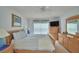 Cozy bedroom with soft, natural light, featuring striped bedding, ceiling fan, and light wood dresser at 2721 Kokomo Loop, Haines City, FL 33844
