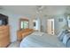 Comfortable main bedroom featuring a ceiling fan, light wood furniture and blue striped bedding at 2721 Kokomo Loop, Haines City, FL 33844