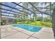 Inviting screened-in pool area surrounded by lush greenery at 2721 Kokomo Loop, Haines City, FL 33844