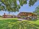 View of the house and covered patio featuring an expansive backyard with lush green grass at 2726 Prine Rd, Lakeland, FL 33810
