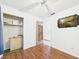 This bedroom features wood floors, a ceiling fan, and a door with a decorative wood accent at 2726 Prine Rd, Lakeland, FL 33810