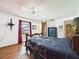 Cozy bedroom featuring wood floors, a rustic headboard, and window with outside view at 2726 Prine Rd, Lakeland, FL 33810