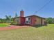 Side view of a brick house with a red chimney and well-maintained lawn at 2726 Prine Rd, Lakeland, FL 33810