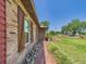 Brick exterior home with wooden shutters, lush landscaping, and a red brick walkway along the side at 2726 Prine Rd, Lakeland, FL 33810