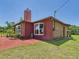 Exterior of home featuring brick and red finishes, and a well-kept lawn at 2726 Prine Rd, Lakeland, FL 33810