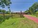 Spacious property featuring a charming home, fenced yard, and extended driveway leading to a covered carport at 2726 Prine Rd, Lakeland, FL 33810