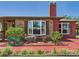 Cozy brick home with lush front yard, green hose, mature plants, a bear statue, and stylish bay windows at 2726 Prine Rd, Lakeland, FL 33810