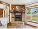 Close-up of stone fireplace, wood mantle with decor, and large window with a neighborhood view at 2726 Prine Rd, Lakeland, FL 33810