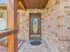 Charming brick home entrance with a covered porch and decorative oval glass front door and brick paved walkway at 2726 Prine Rd, Lakeland, FL 33810