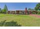 Charming single-story brick home featuring a well-manicured lawn, covered entry, and a classic brick chimney at 2726 Prine Rd, Lakeland, FL 33810