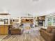 Spacious living room featuring wood flooring, stone fireplace, and comfortable seating at 2726 Prine Rd, Lakeland, FL 33810