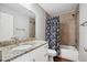 Bathroom featuring granite countertop, undermount sink, shower-tub combo with decorative curtain at 310 N 1St Ave, Bartow, FL 33830