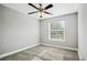 Simple, carpeted bedroom with a ceiling fan and a large window for natural light at 310 N 1St Ave, Bartow, FL 33830