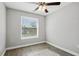 Bright bedroom featuring a modern ceiling fan, gray walls, wood-look floors, and natural light from a large window at 310 N 1St Ave, Bartow, FL 33830