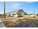 A street of modern townhomes with gray siding and well-manicured lawns under a clear blue sky at 310 N 1St Ave, Bartow, FL 33830