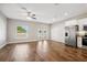 Open-concept living space with hardwood floors, stainless steel appliances, and a ceiling fan at 310 N 1St Ave, Bartow, FL 33830