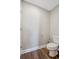 Simple toilet room with hardwood floors, baseboards, and white walls at 310 N 1St Ave, Bartow, FL 33830