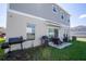 View of a backyard featuring a patio set, grills and an open lawn space surrounded by a two-story house at 3440 Dahlia Dr, Haines City, FL 33844