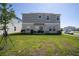 Expansive backyard with green lawn, patio set, and views of the home's exterior, ideal for outdoor activities at 3440 Dahlia Dr, Haines City, FL 33844
