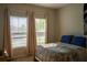 Inviting bedroom featuring natural light from two large windows and a cozy bed with blue pillows at 3440 Dahlia Dr, Haines City, FL 33844