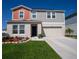Charming two-story home with a well-manicured lawn, attached garage, and welcoming front entrance at 3440 Dahlia Dr, Haines City, FL 33844