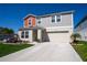 Front of the house with a two-car garage, lawn, and landscaping at 3440 Dahlia Dr, Haines City, FL 33844