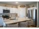 Modern kitchen featuring white cabinets, stainless steel appliances, and a cozy breakfast bar with stylish seating at 3440 Dahlia Dr, Haines City, FL 33844